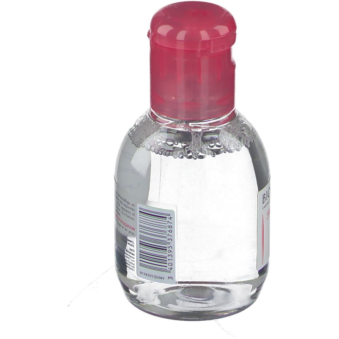 Petite bouteille ovale avec bouchon rose. Étiquette code-barres. Indication de volume non visible.