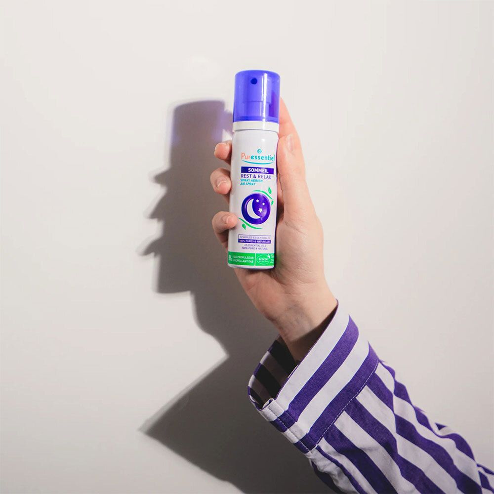 Personne tenant un flacon spray violet. Texte : Sommeil Rest & Relax. Logo lune et étoiles.