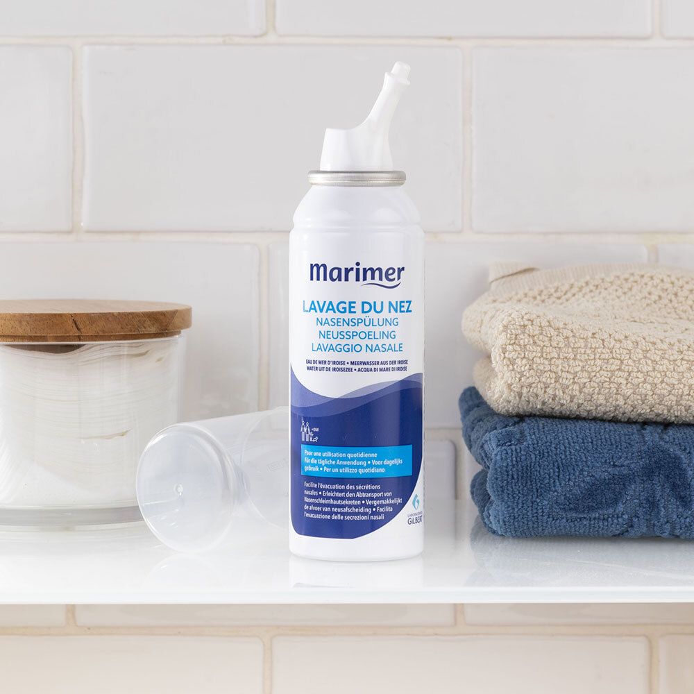 Spray nasal avec capuchon. Marque Marimer. Texte : Lavage du Nez, Nasenspülung, Lavaggio Nasale. Sur une étagère.