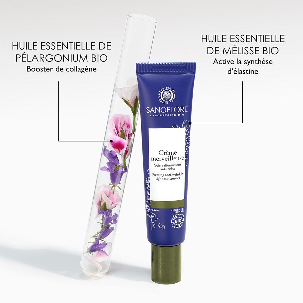 Tube à essai avec fleurs à côté du tube. Sanoflore Crème merveilleuse. Contient huile essentielle de Pélargonium et Mélisse.