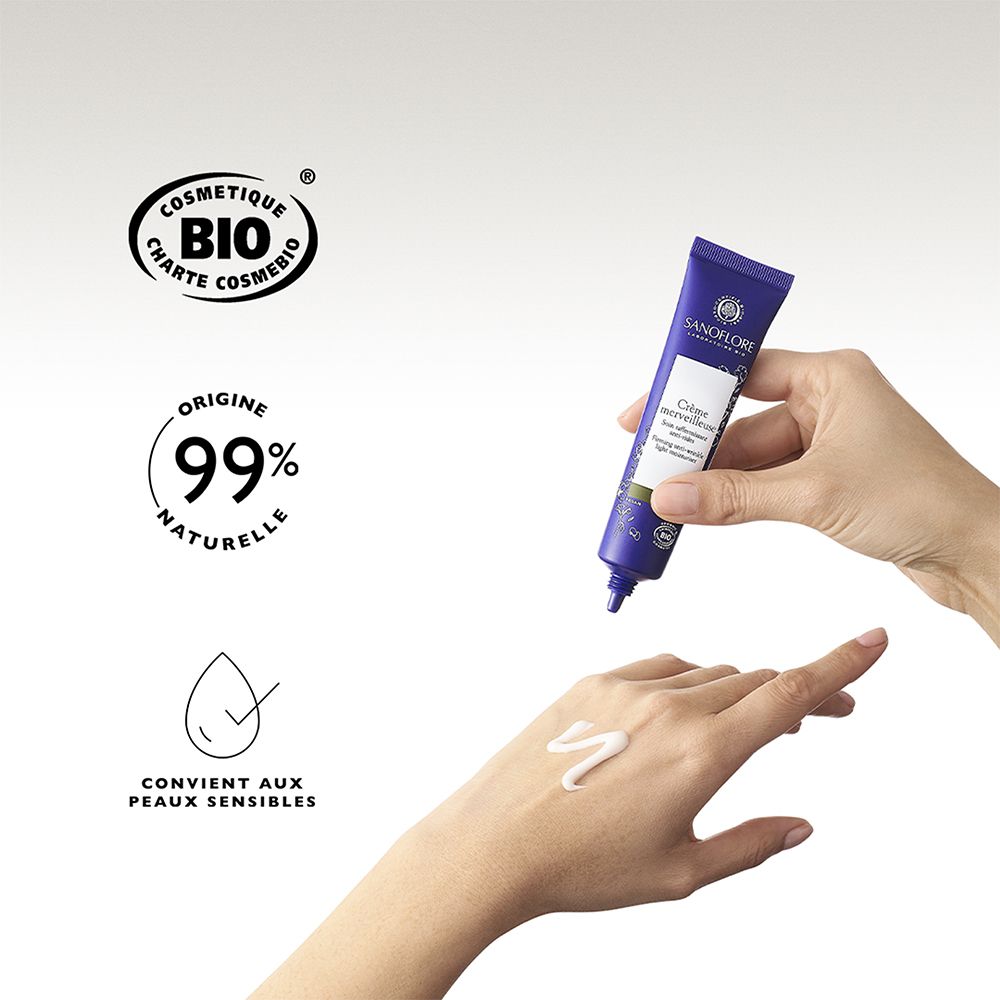 Main avec crème. Sanoflore Crème merveilleuse. 99% naturel. Convient aux peaux sensibles. Certification bio.