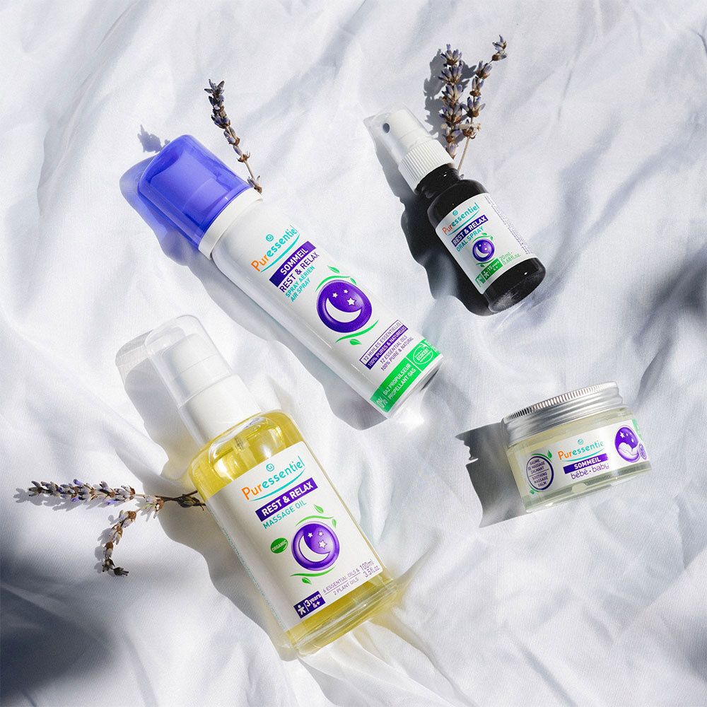 Divers produits Puressentiel : huile de massage, spray, crème. Brins de lavande. Symbole lune et étoiles.