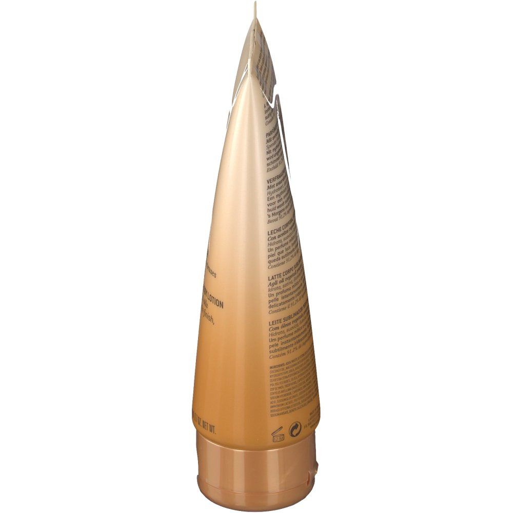 Tube beige et doré vu de côté. Le bouchon est doré. Inscription: Prodigieux lait parfumé. Texte sur le côté.