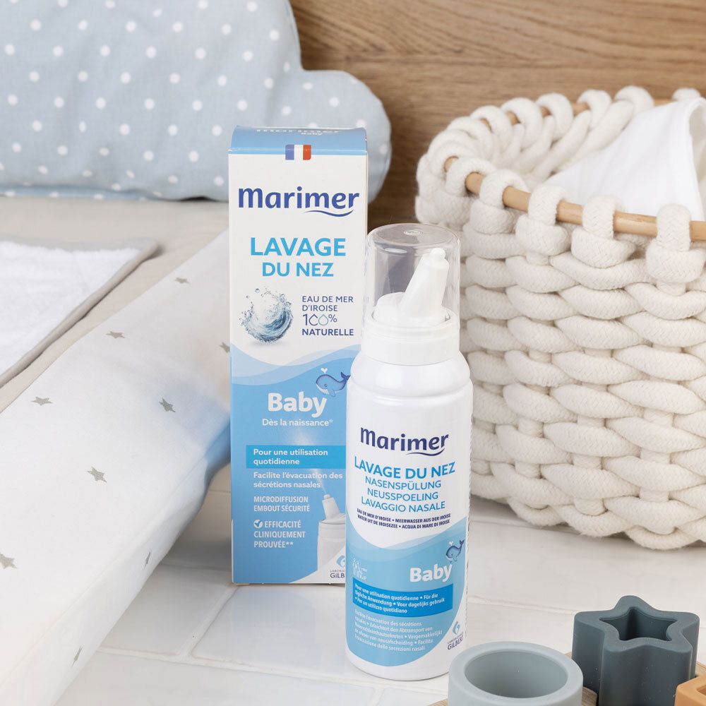 Produit et emballage sur fond clair. Inscription: Marimer, Lavage du nez. Pour bébé. À côté de jouets.