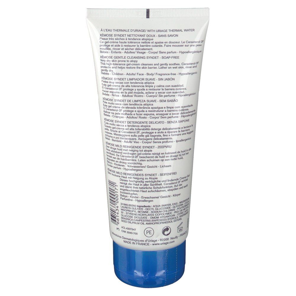 Dos du tube. Texte multilingue. Bouchon bleu. Corps du tube blanc.