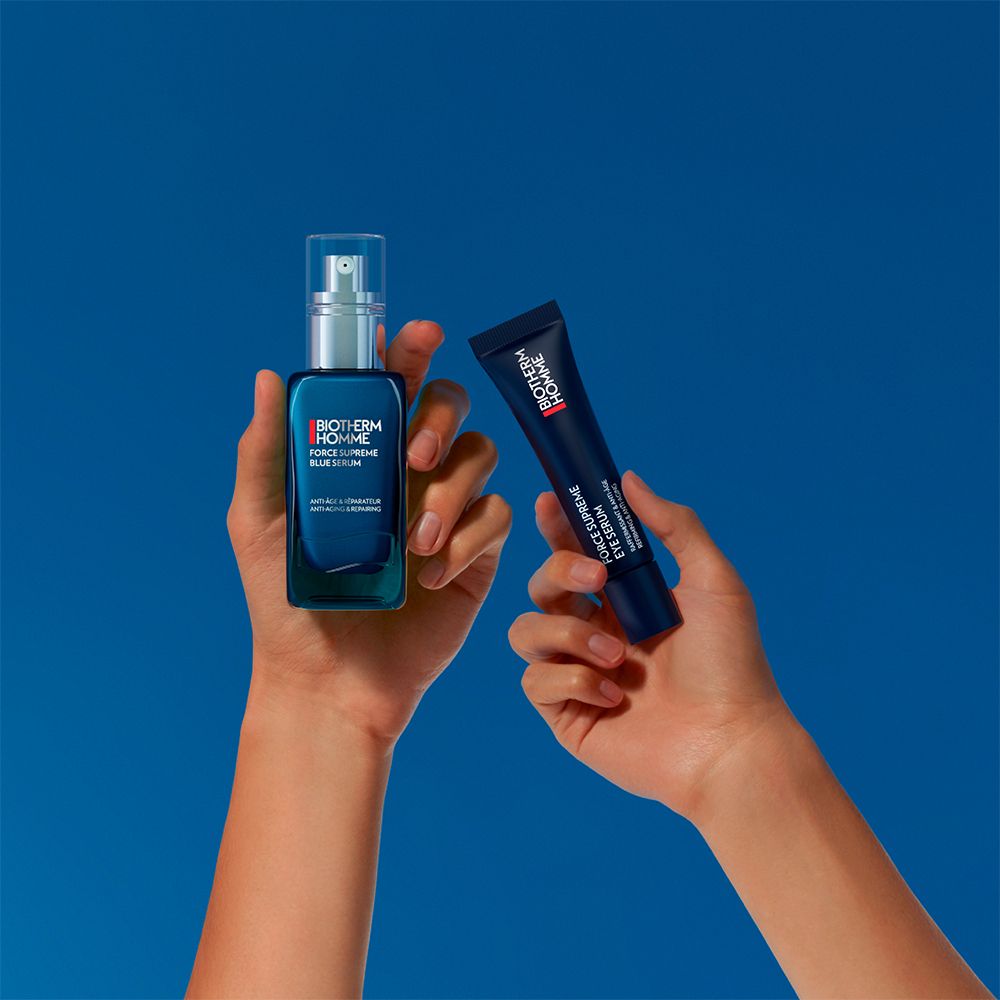 Mains tenant une bouteille de sérum et un tube Biotherm Homme.