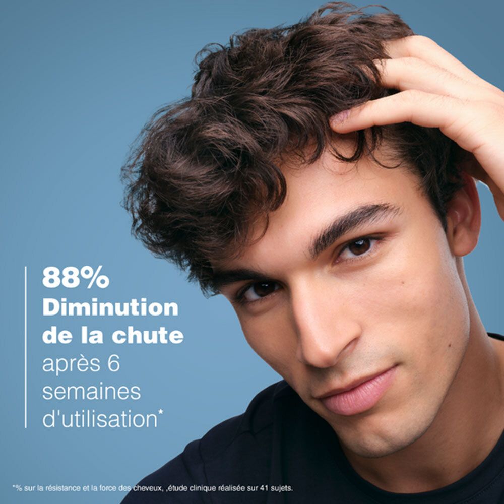 Homme touchant ses cheveux. Texte: 88% Diminution de la chute après 6 semaines.