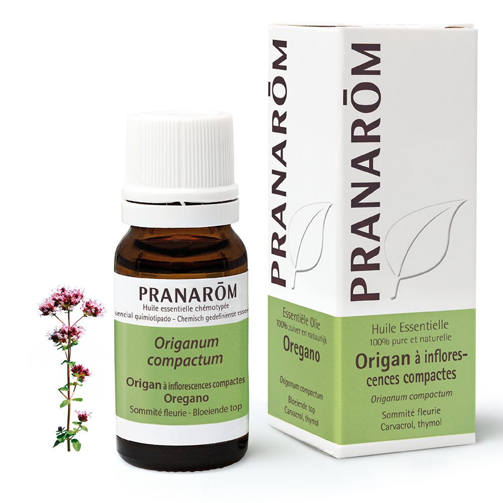 Flacon en verre brun avec bouchon blanc et étiquette. Boîte avec informations produit et fleurs en arrière-plan.