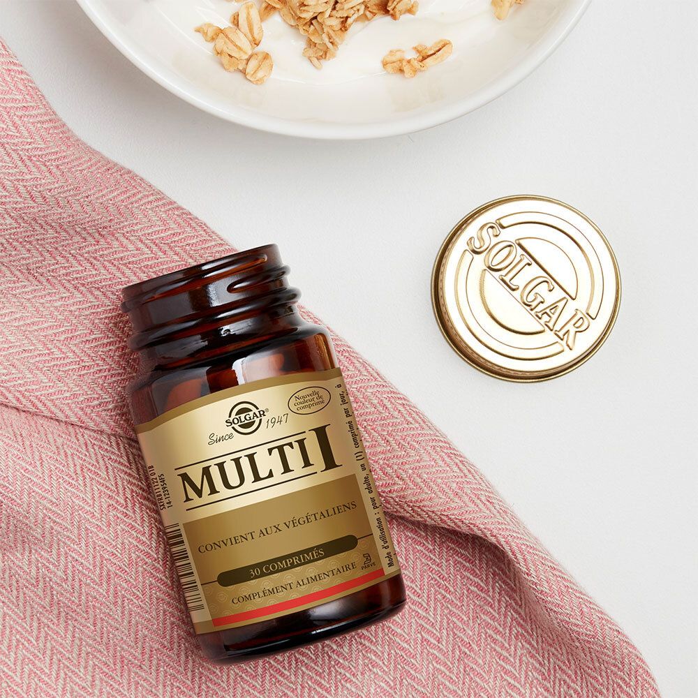 Flacon brun, bouchon doré, logo SOLGAR. Posé sur tissu rose, à côté d'un bol de granola.