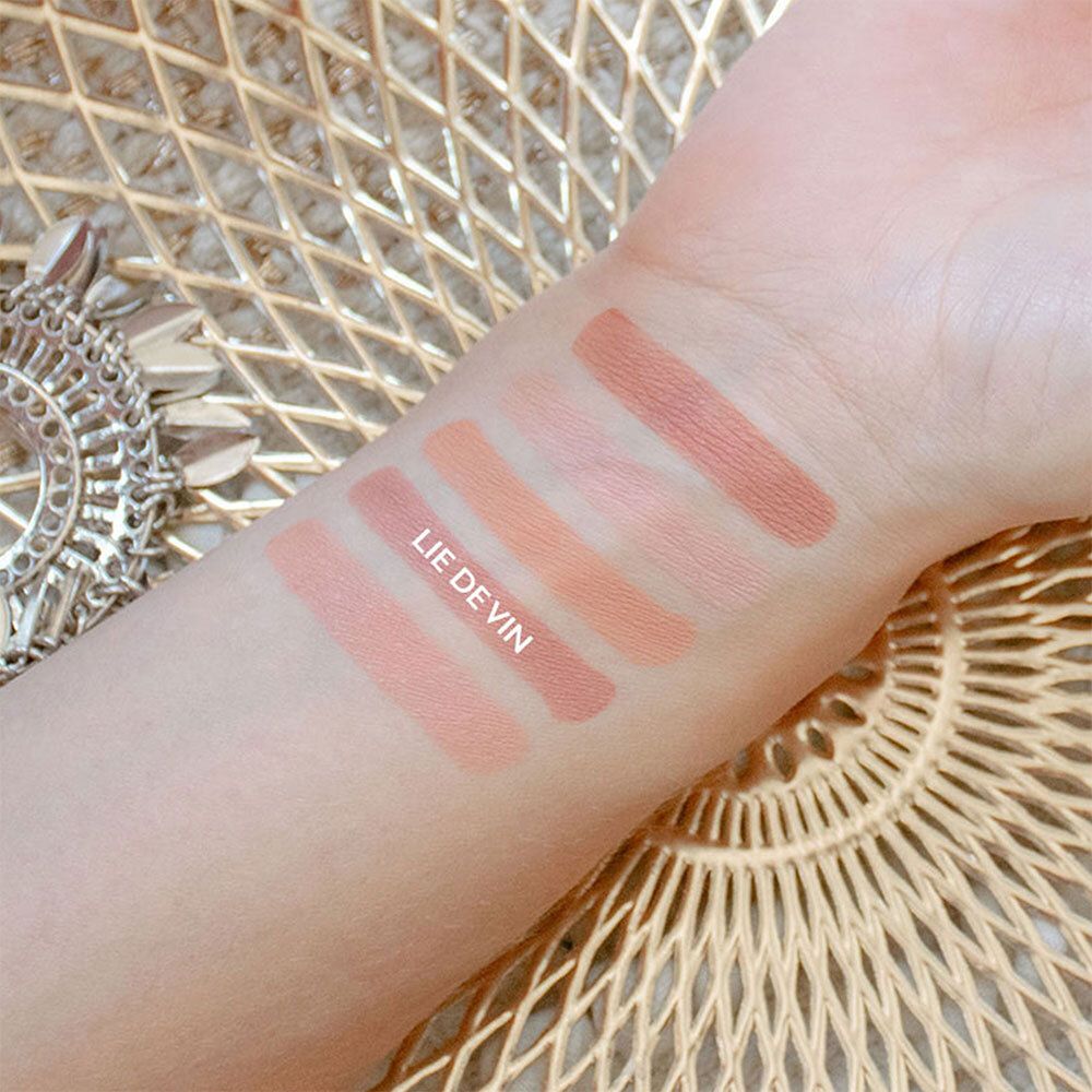 Main avec cinq échantillons de couleurs. Nuances de rose. Inscription: LIE DE VIN.