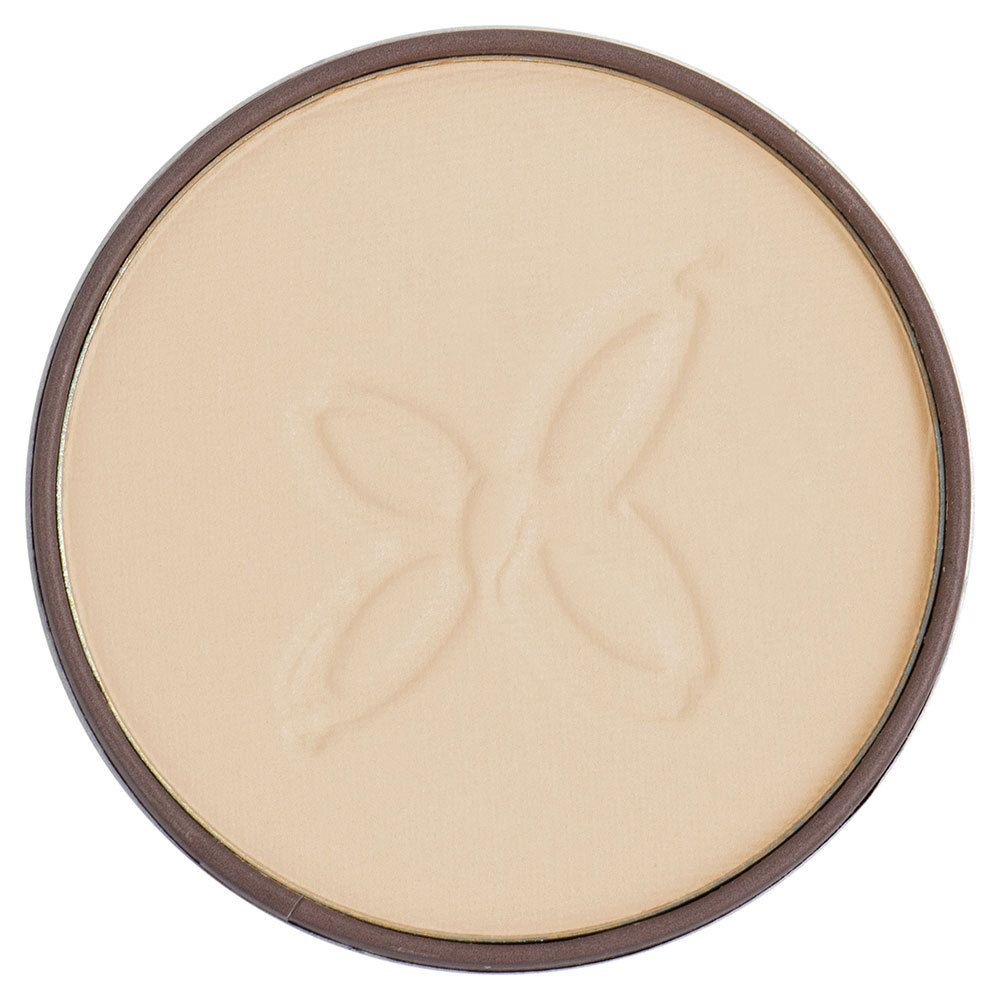 Gros plan sur la poudre compacte. Couleur claire avec motif papillon en relief. Forme ronde.