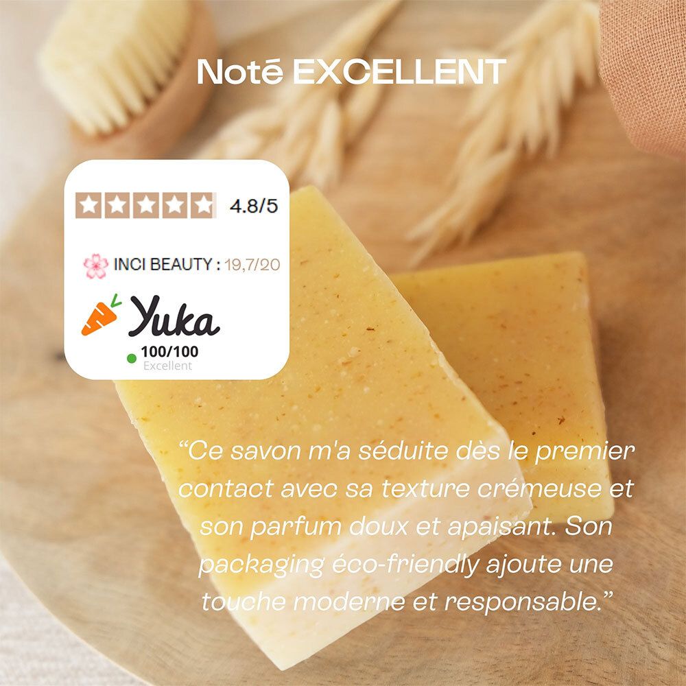 Deux savons OMUM Le Cajoleur sur une planche en bois, avec évaluation Yuka.