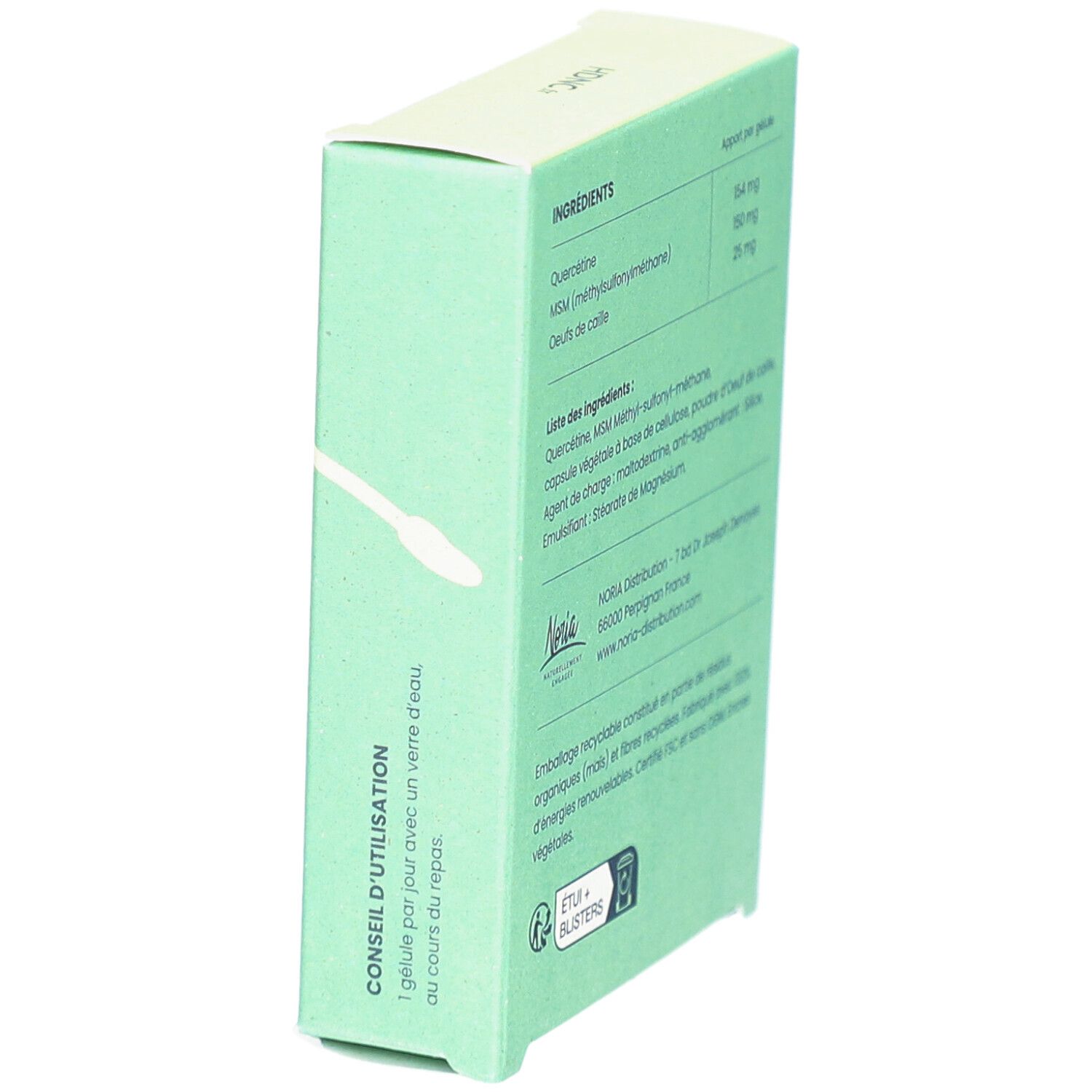 Boîte vert clair avec texte. Contient des informations d'utilisation: 1 gélule par jour avec de l'eau. Logo de recyclage.