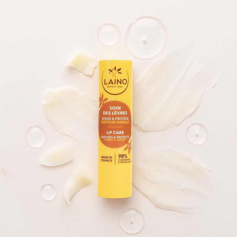 Stick de soin des lèvres jaune LAINO, Soin des Lèvres, Vanille. Entouré de taches de crème et d'huile. 98% ingrédients naturels.