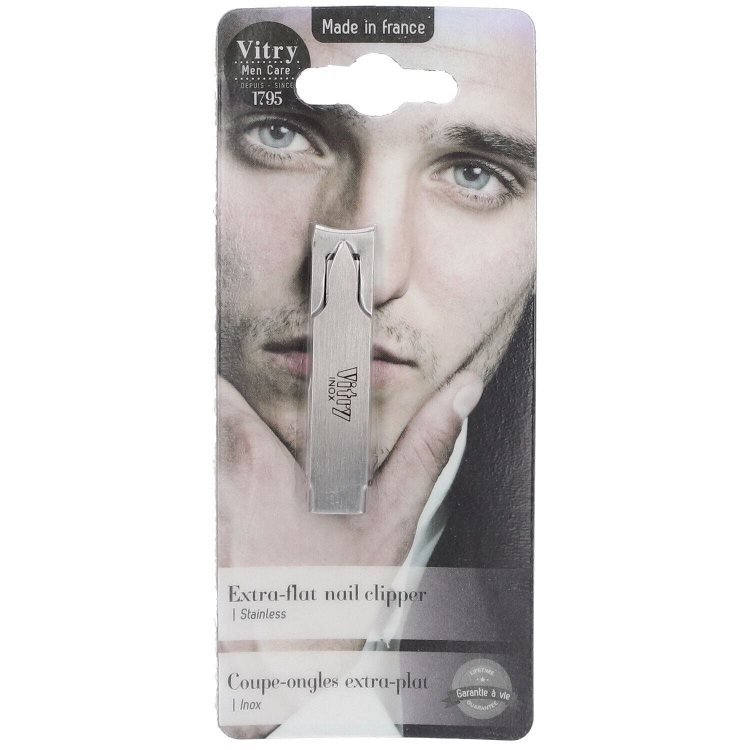 Coupe-ongles extra-plat en acier inoxydable. Sur carte avec visage d'homme. Marque Vitry. Texte 'Extra-flat nail clipper'.