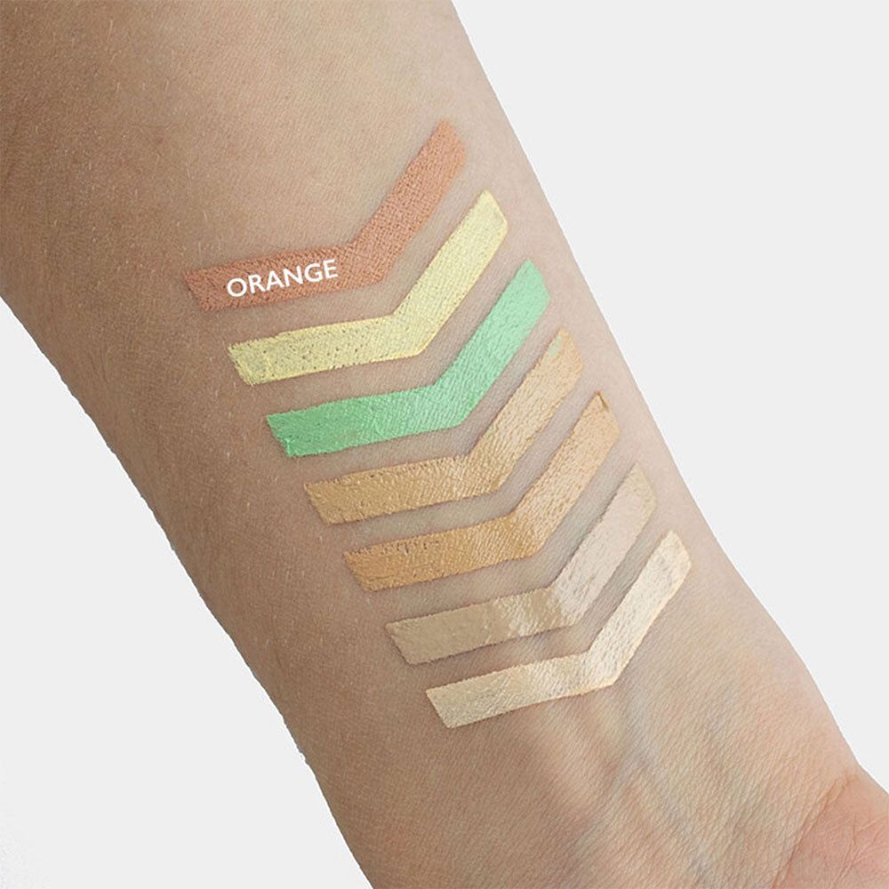 Bras avec échantillons de couleurs. Correcteur orange. Différentes nuances appliquées en forme de flèche. Inscription : ORANGE.
