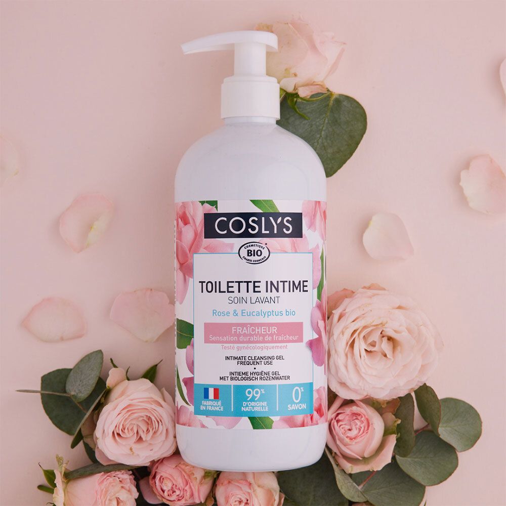 Flacon blanc avec pompe entouré de pétales de roses. Inscription: Coslys, Toilette Intime, Rose & Eucalyptus bio. Drapeau français.