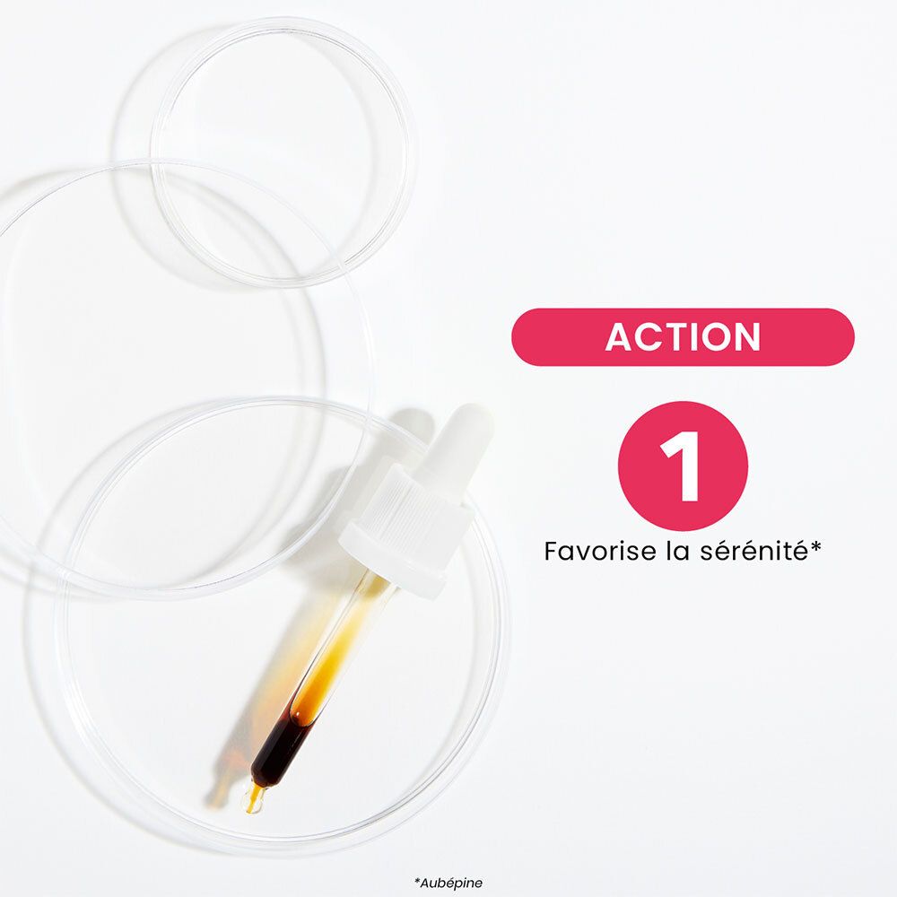 Main tenant une pipette au-dessus d'un verre vert. Goutte qui tombe. Fond : plaque de marbre.