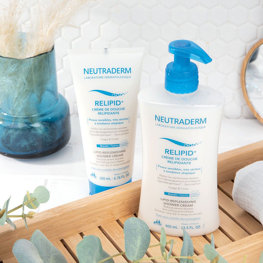 Deux produits sur un plateau. Flacon blanc avec pompe bleue et tube. Inscription: NEUTRADERM, RELIPID+ Crème de Douche Relipidante.