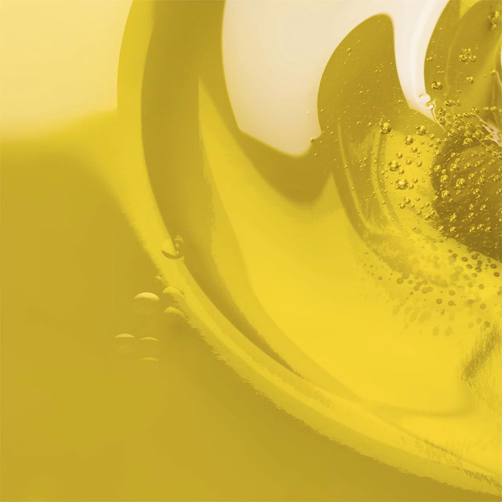Gros plan sur un liquide jaune avec des tourbillons et des bulles. Texture huileuse.