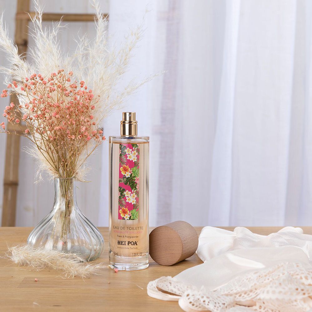 Flacon de HEI POA® Eau de Toilette sur une table. À côté, des fleurs séchées et un morceau de tissu.
