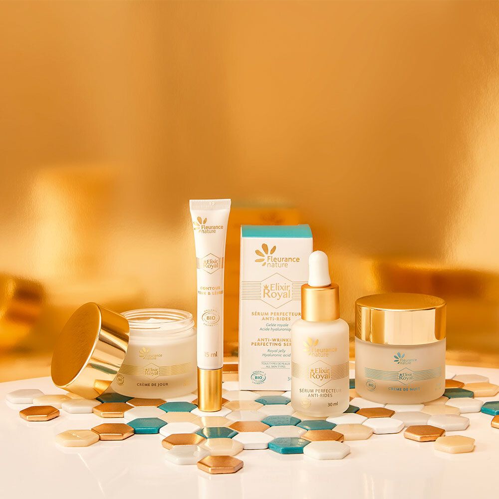 Ensemble de produits avec crèmes, sérum et tube. Emballage doré et blanc. Inscription: Elixir Royal.