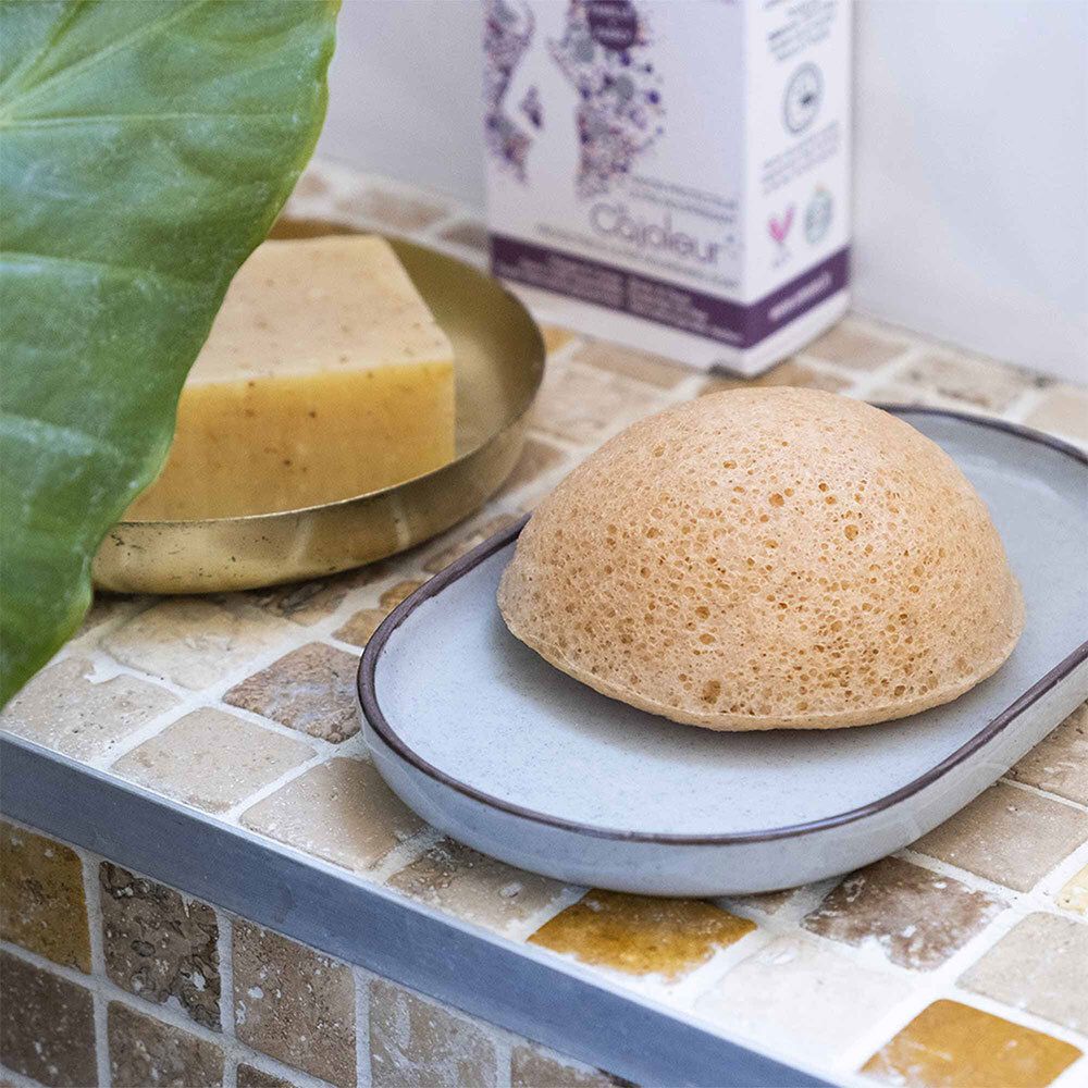 Éponge Konjac sur un porte-savon dans une salle de bain.