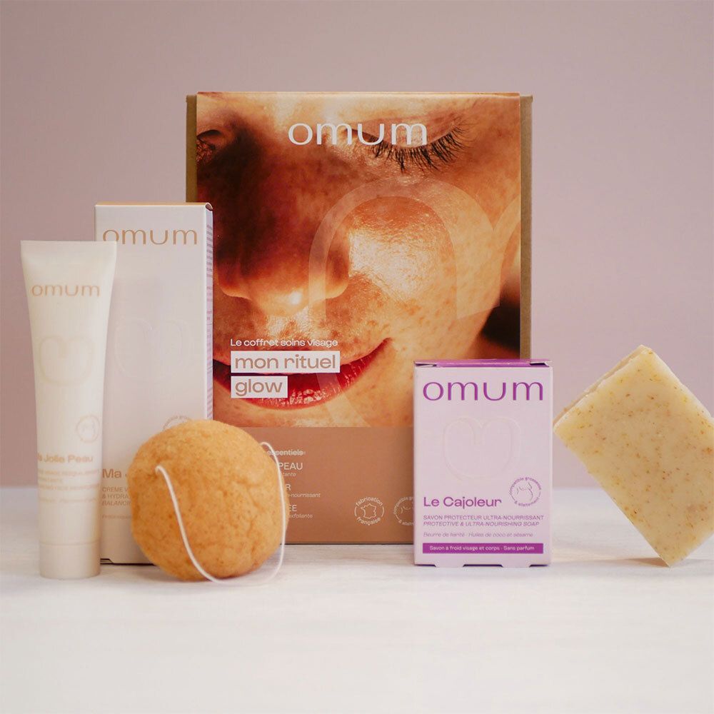 Boîte cadeau OMUM avec crème visage, savon, éponge konjac et petits emballages.