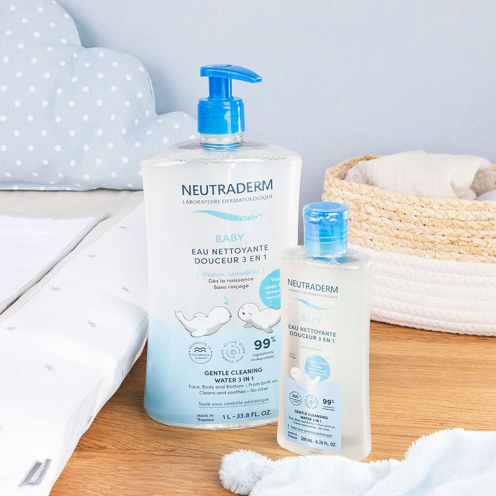 Deux flacons de Neutraderm Baby Eau nettoyante. Un grand et un petit. Sur une table à langer. Accessoires bébé.