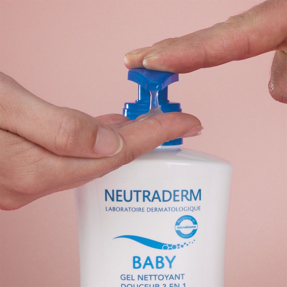 Main pressant du gel de la pompe bleue d'un flacon blanc. Marque : Neutraderm Baby.