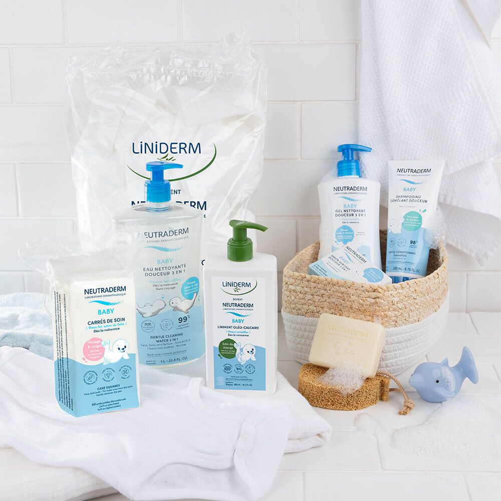 Divers produits Neutraderm Baby dans une salle de bain. Bouteilles, lingettes et un savon dans un panier.
