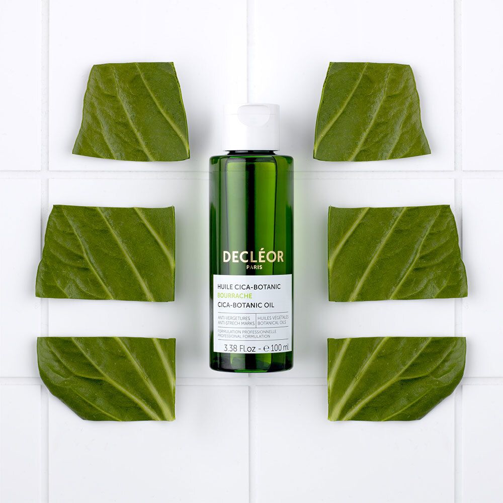 Flacon entouré de feuilles. Texte: DECLÉOR, HUILE CICA-BOTANIC. Vert et blanc.