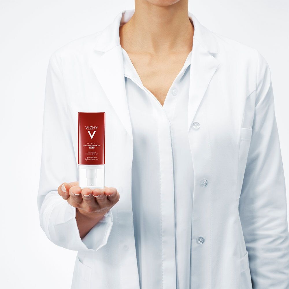 Personne tenant tube rouge. Blouse blanche. Logo Vichy et nom du produit.