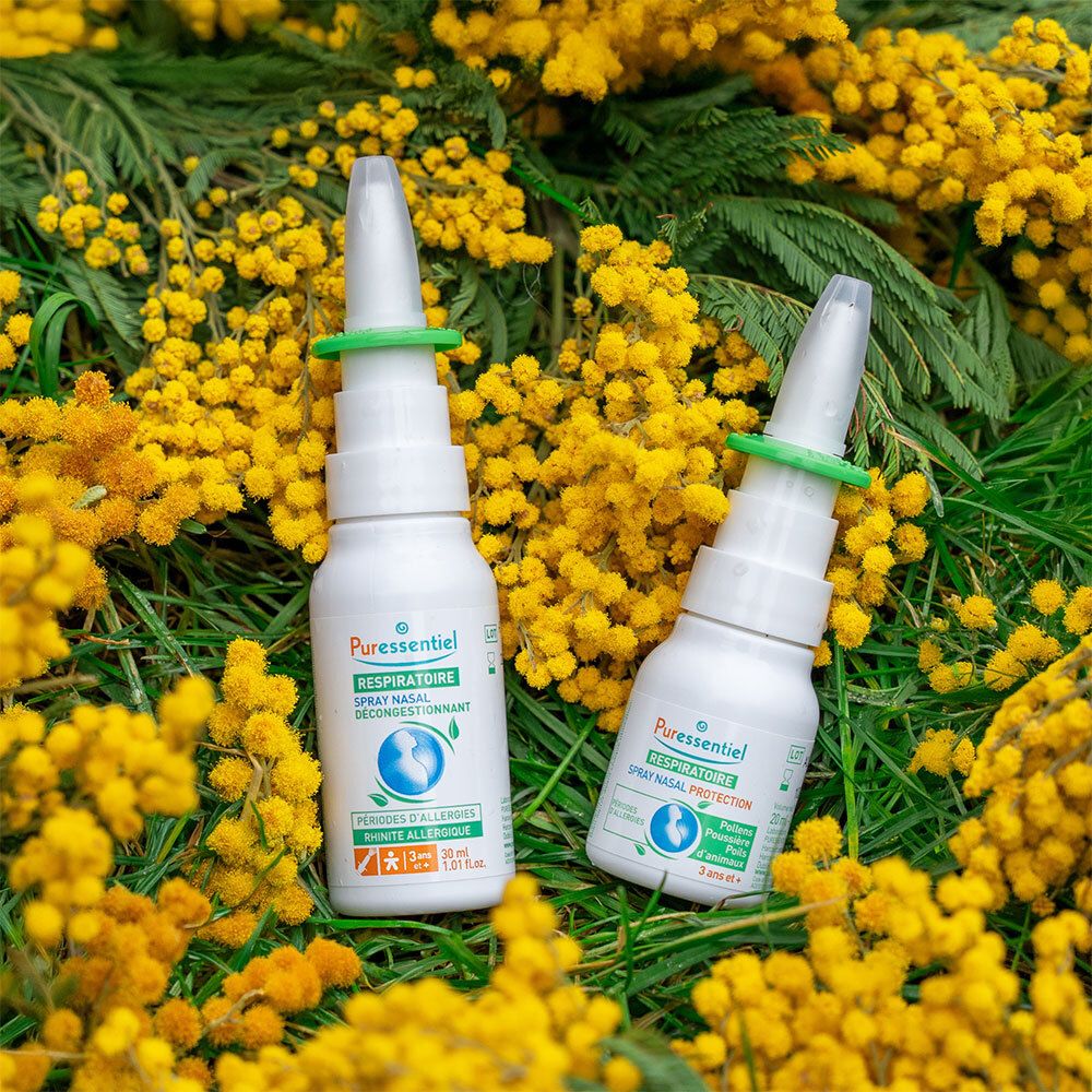 Deux flacons de spray nasal avec anneau vert. Inscription: Puressentiel Respiratoire. Fleurs jaunes et herbe.