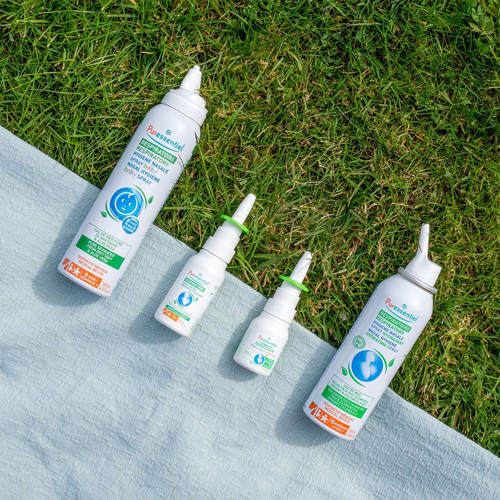 Trois flacons de spray nasal et un vaporisateur. Inscription: Puressentiel Respiratoire. Sur tissu bleu.