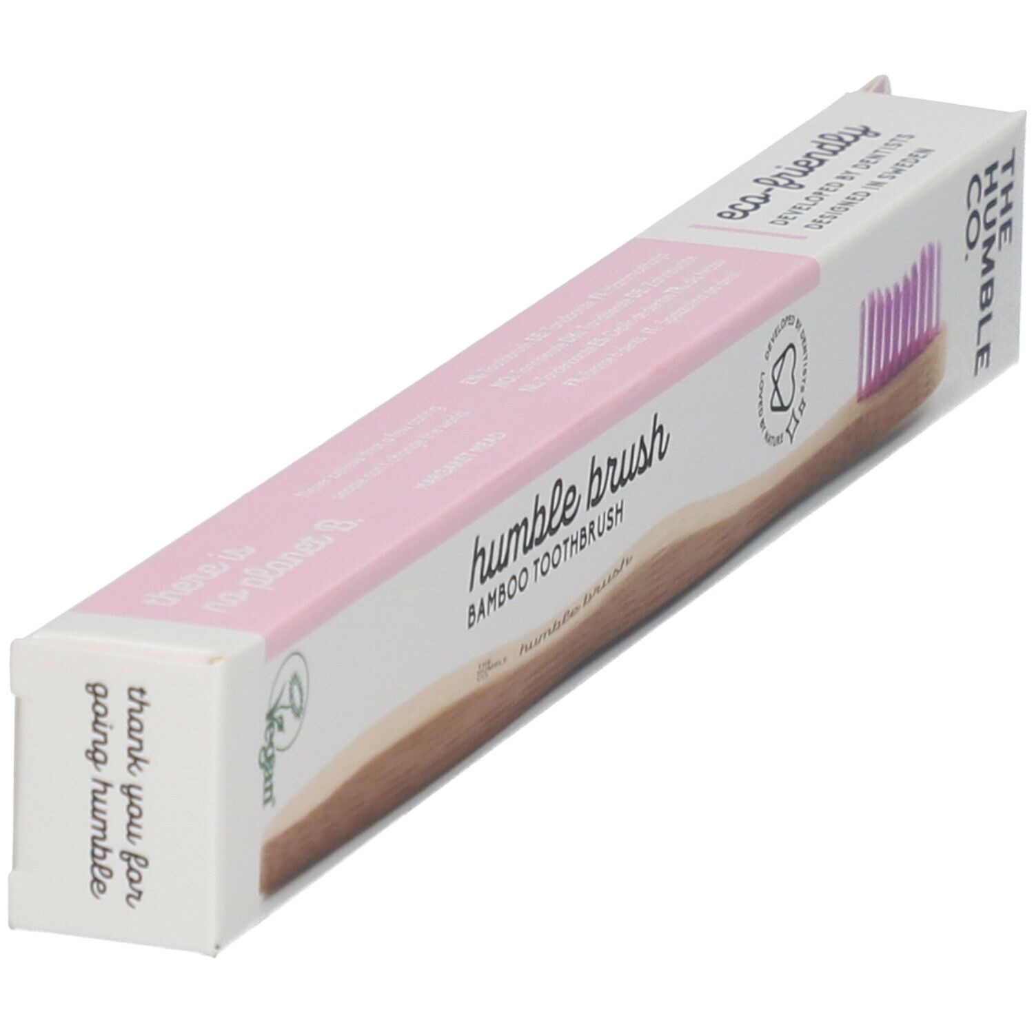 Emballage de brosse à dents. Accents roses, manche en bambou, logo et texte. Label vegan. Vue en angle.