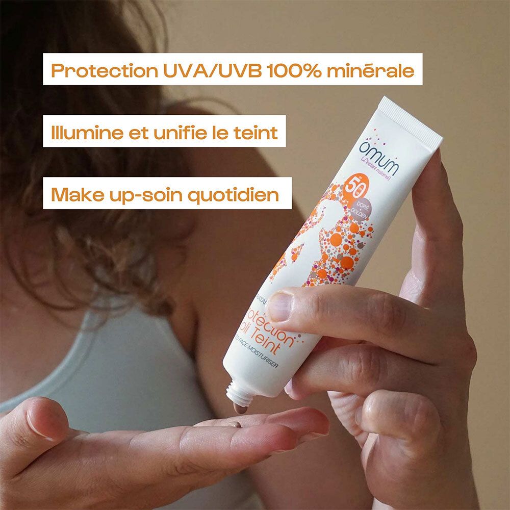 Main tenant le tube OMUM MA PROTECT JOLI TEINT, montrant la protection UVA/UVB 100% minérale.