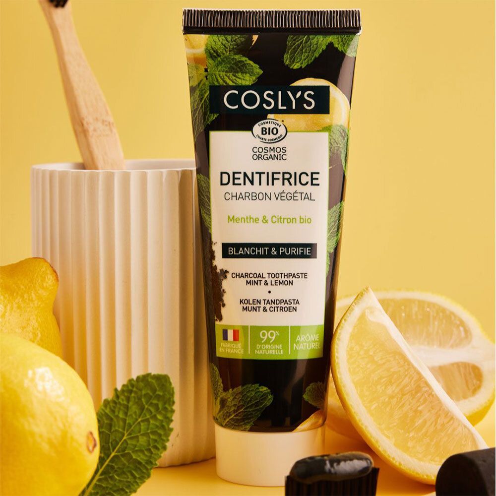 Tube de dentifrice avec citrons, menthe et brosse à dents. Texte: COSLYS, Dentifrice, Charbon Végétal, Menthe & Citron bio.