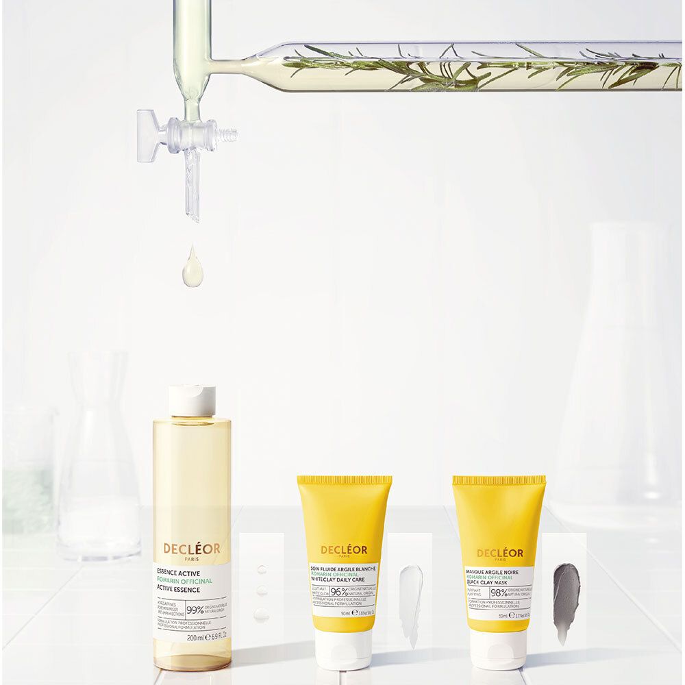 Trois produits et matériel de laboratoire. Produits: Essence Active, Fluide Argile Blanche, Masque Argile Noire.