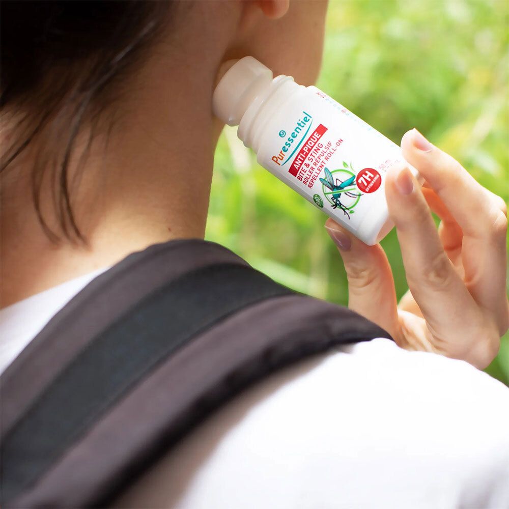 Personne appliquant le roll-on Anti-Pique Puressentiel sur le cou. Flacon blanc, bouchon rouge.