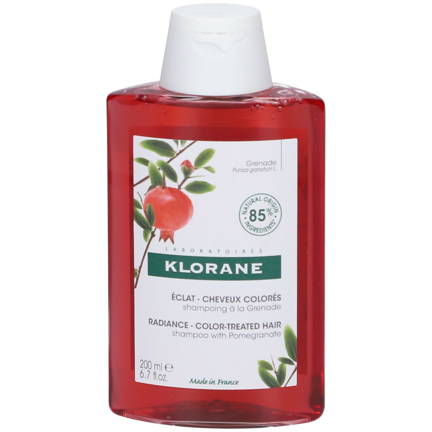 Flacon de shampooing rouge avec bouchon blanc. Étiquette avec illustration de grenade et texte: KLORANE, ÉCLAT - CHEVEUX COLORÉS.