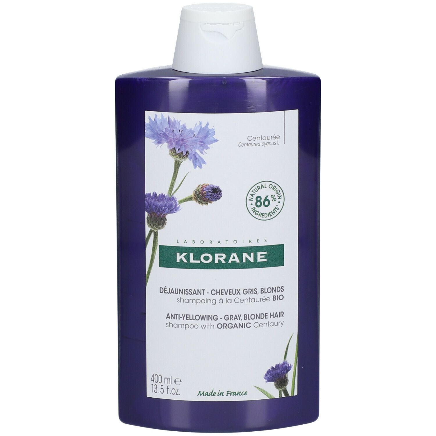 Flacon de shampooing violet avec bouchon blanc. Inscription: KLORANE, shampooing anti-jaunissement pour cheveux gris et blonds à la Centaurée BIO.