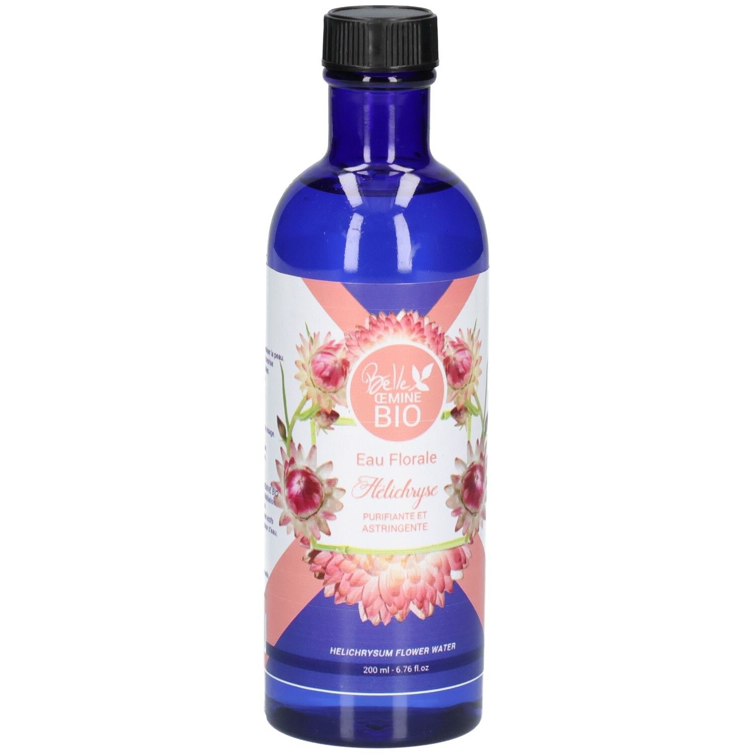 Flacon en verre bleu avec bouchon noir, étiquette ornée de fleurs roses et blanches et de texte.
