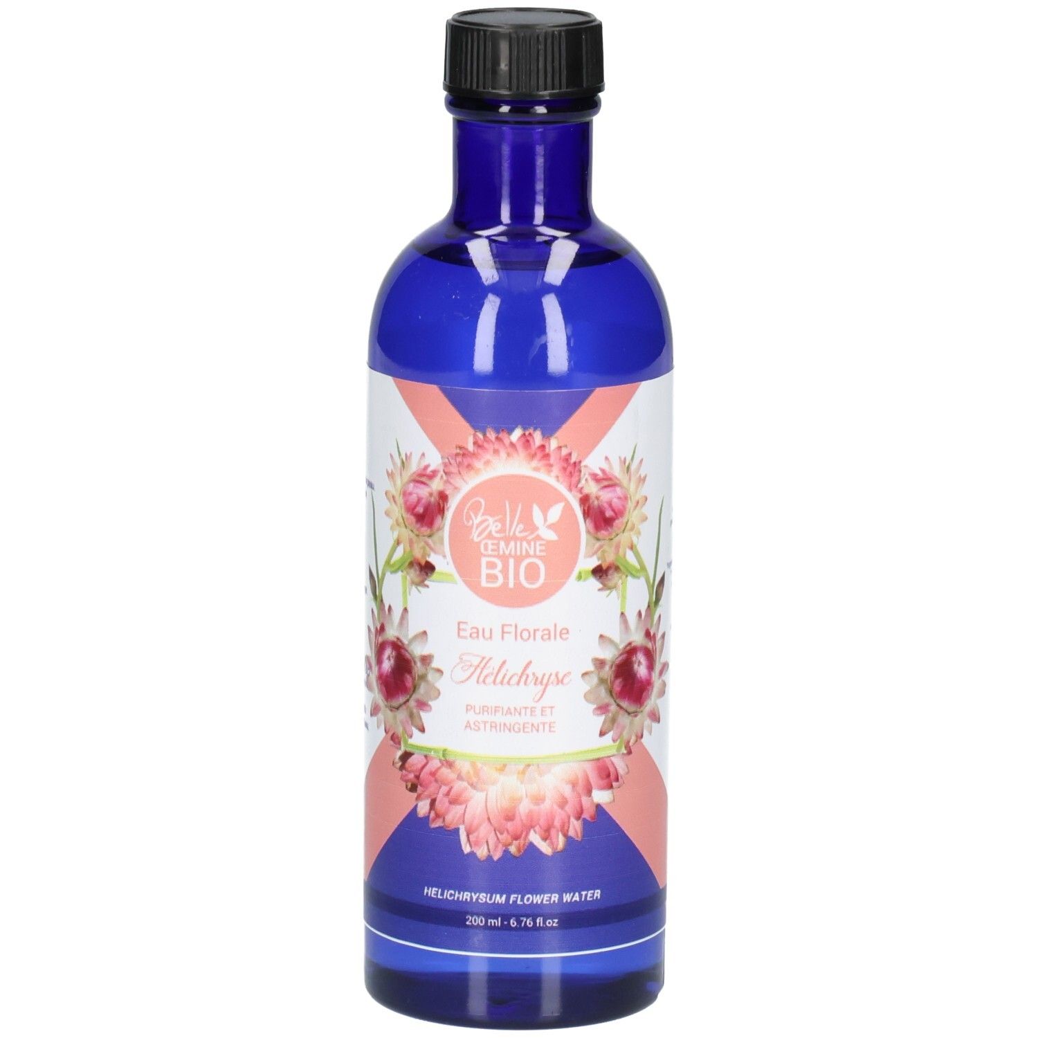 Flacon en verre bleu avec bouchon noir, étiquette ornée de fleurs roses et blanches et de texte.