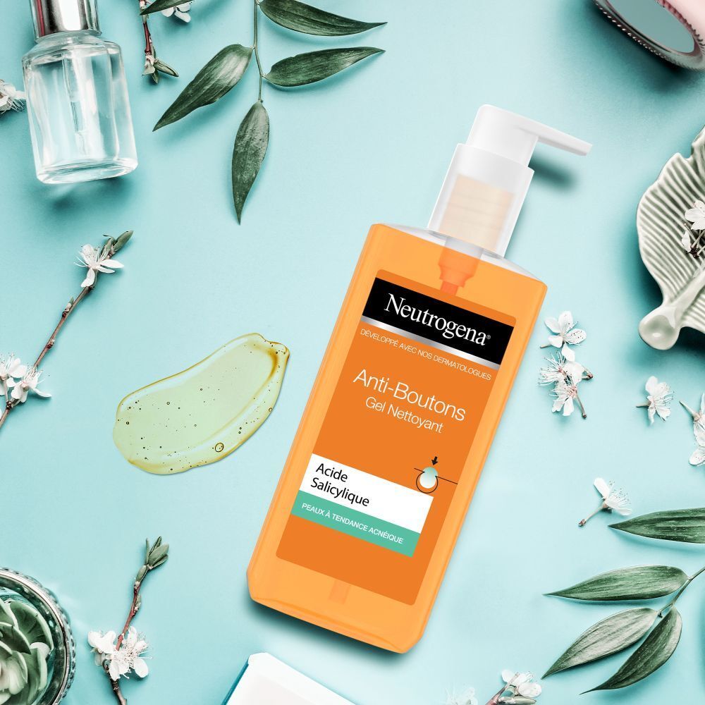 Gel Neutrogena Anti-Boutons sur fond bleu. Échantillon de gel à côté. Autres produits en arrière-plan.