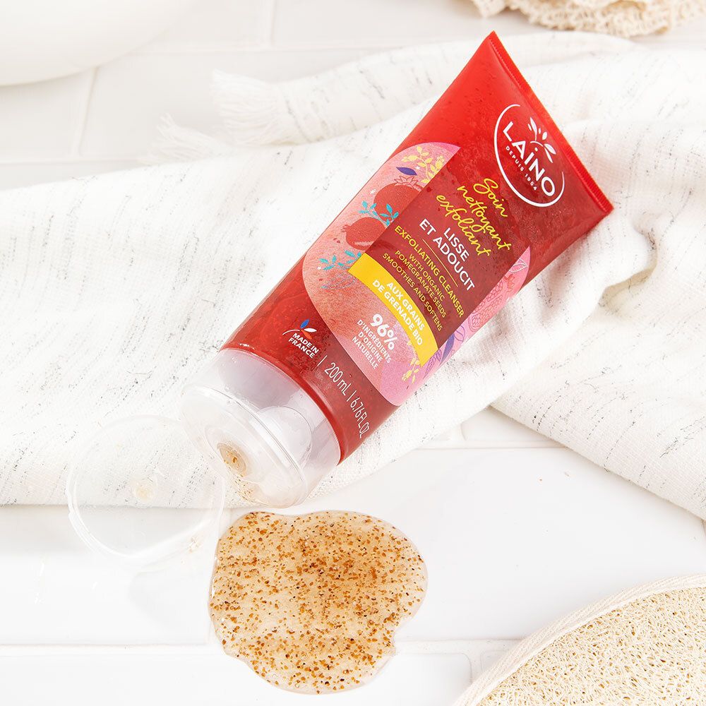 Tube rouge à côté d'une goutte de produit. Nom du produit et logo visibles. Sur fond blanc.