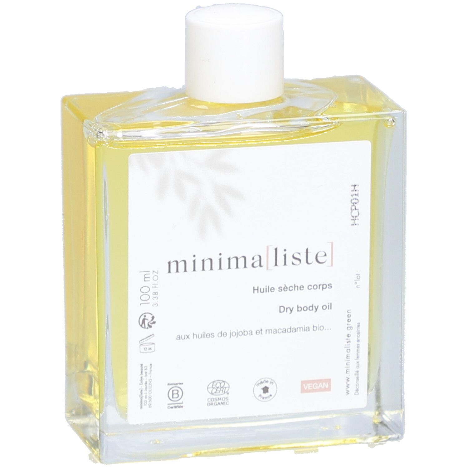 Flacon en verre avec huile jaune et bouchon blanc. Étiquette avec nom du produit et informations. Gros plan.