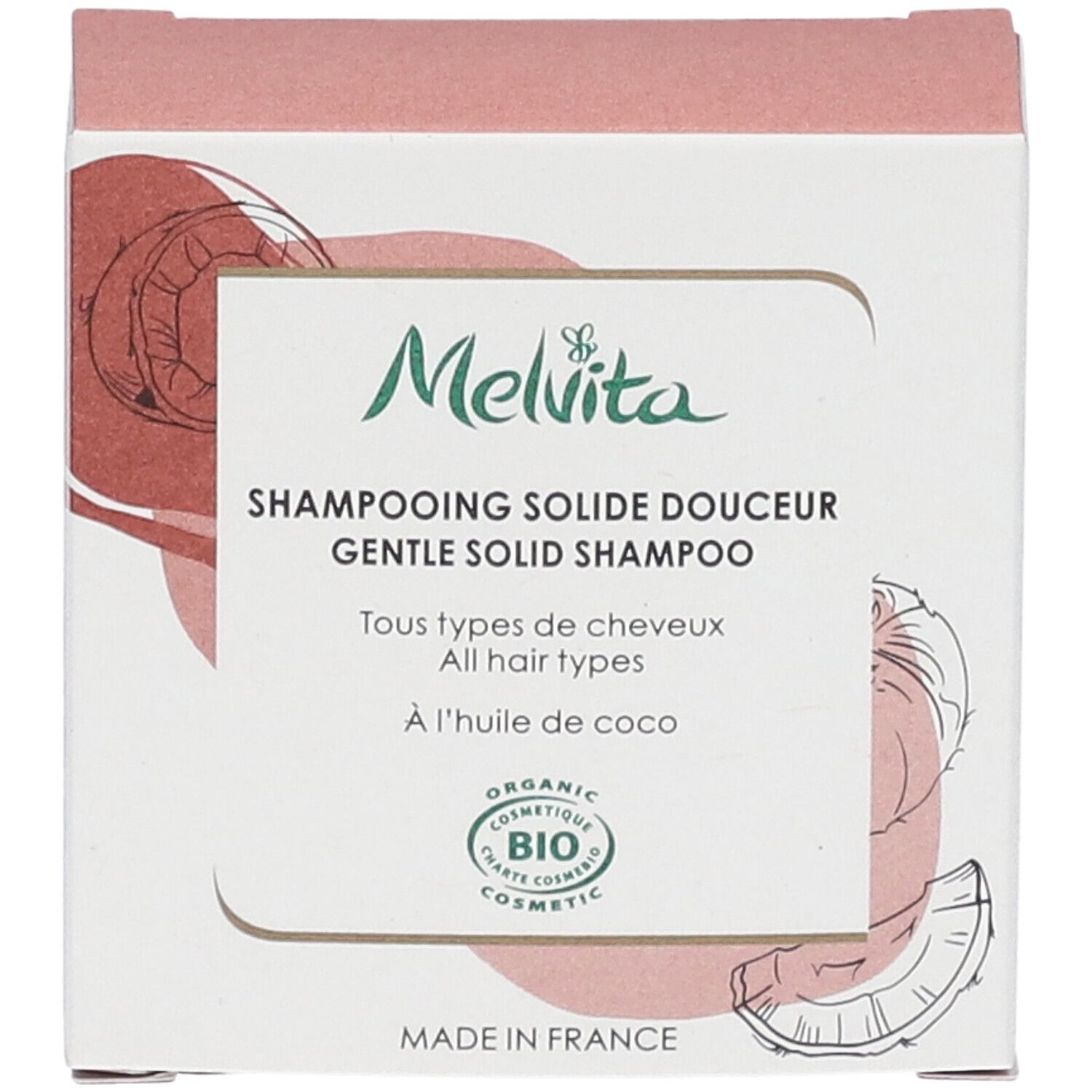 Vue de face de l'emballage du shampooing. Texte : "Melvita", "Shampooing solide douceur", "BIO COSMETIC". Illustration noix de coco.