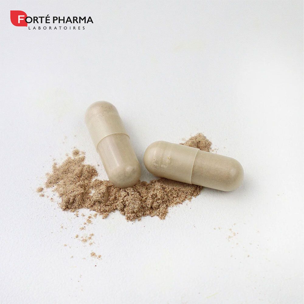 Deux gélules beiges et poudre brune sur fond blanc. Les gélules sont oblongues.
