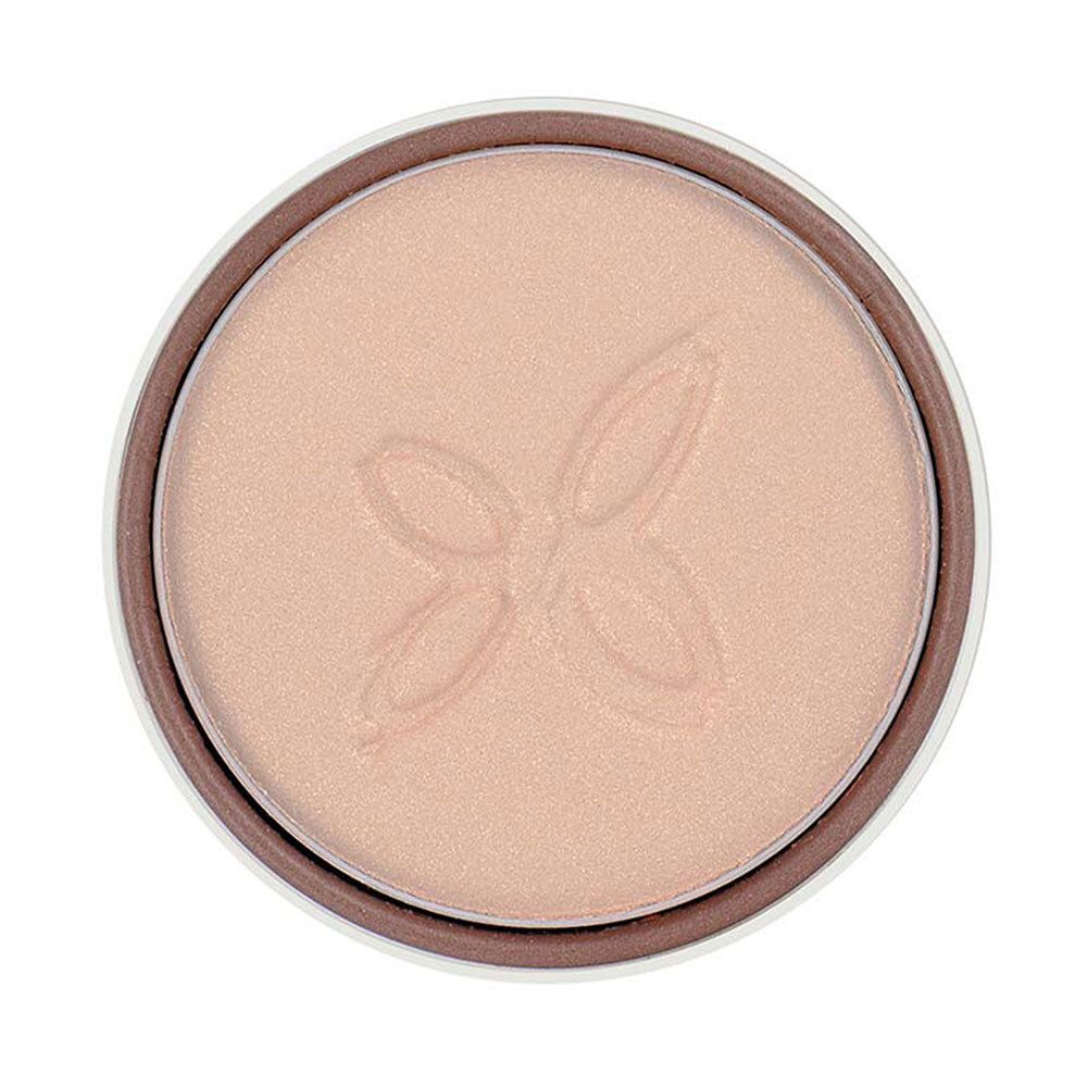 Boîte ronde marron avec fard à paupières clair. Produit clair avec motif en relief. Nom du produit non visible.